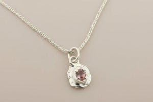 Silver necklace with a pendant on a gray background