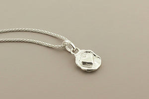 Silver necklace with a pendant on a gray background