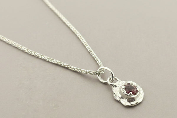 Silver necklace with a pendant on a gray background