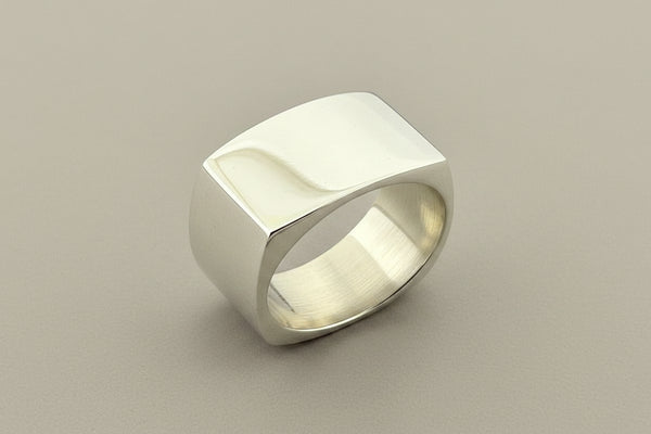 Silver ring with geometric design on a gray background