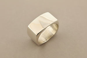Silver ring with a textured surface on a gray background