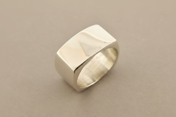 Silver ring with a textured surface on a gray background