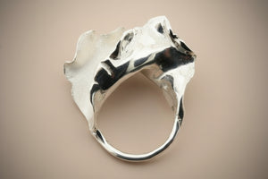 Silver ring with a unique design on a gray background