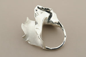 Silver ring with a unique design on a gray background