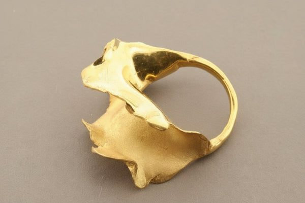 Gold ring with a unique design on a gray background