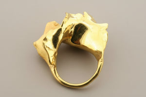Gold ring with a unique design on a gray background