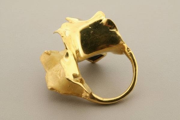 Gold ring with a unique design on a gray background