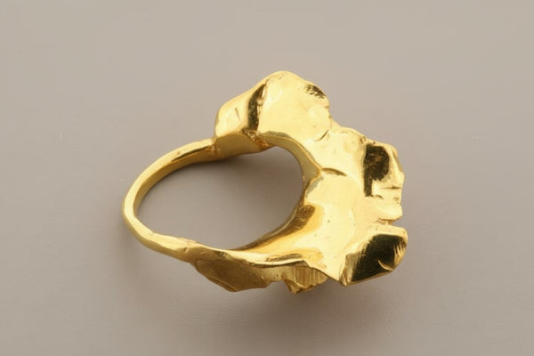 Gold ring with a textured design on a gray background