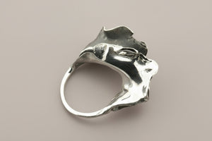 Silver ring with a unique design on a gray background
