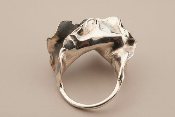 Silver ring with a unique design on a gray background