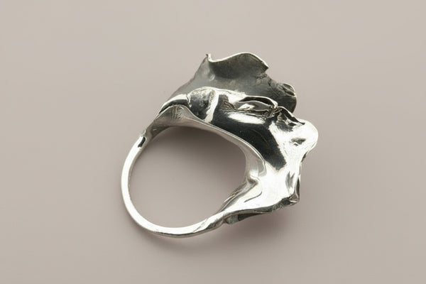 Silver ring with a unique design on a gray background