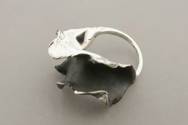 Silver ring with a unique design on a gray background