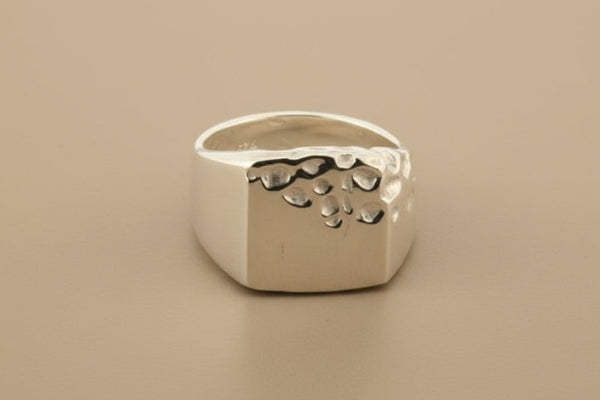 Silver ring with a textured surface on a gray background
