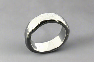 Silver ring with a textured surface on a gray background