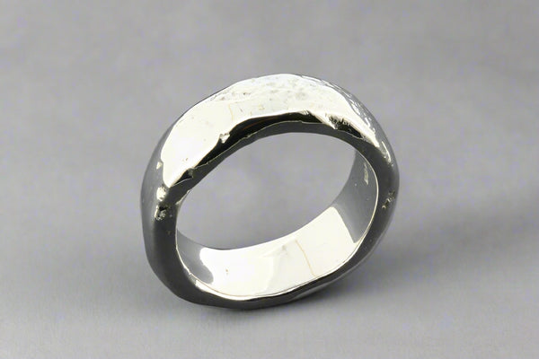 Silver ring with a textured surface on a gray background
