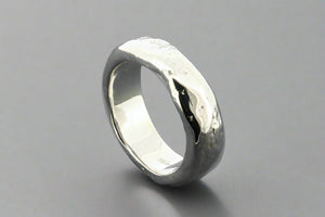 Silver ring with a textured surface on a gray background