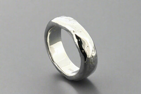 Silver ring with a textured surface on a gray background