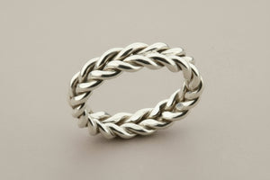 Silver braided ring on a gray background