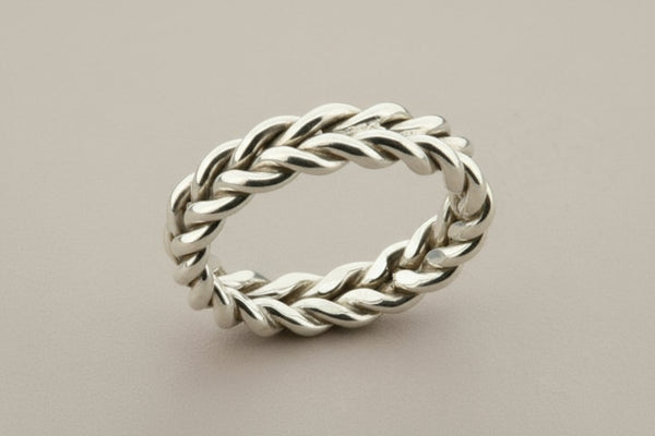 Silver braided ring on a gray background