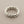 Load image into Gallery viewer, Silver braided ring on a gray background
