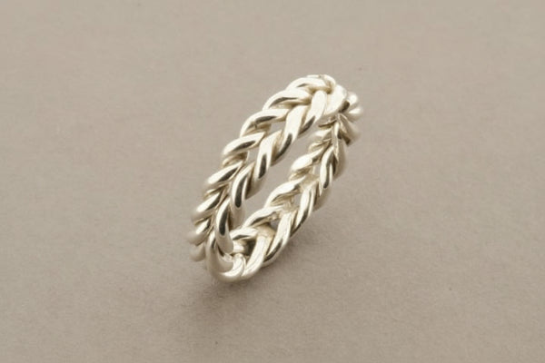 Silver braided ring on a gray background