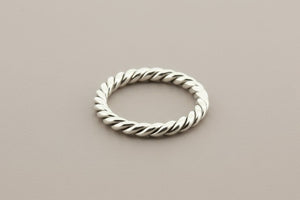 Silver twisted ring on a gray background