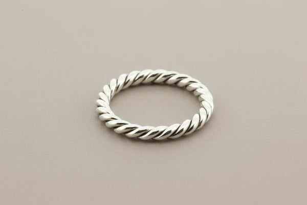 Silver twisted ring on a gray background