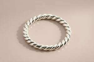 Silver twisted ring on a gray background