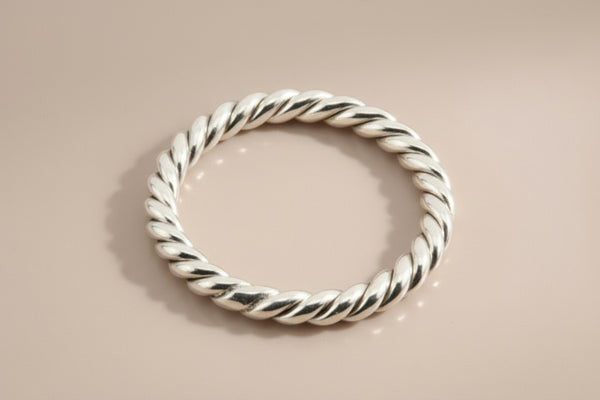 Silver twisted ring on a gray background