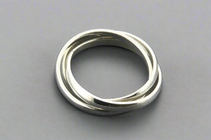 Silver ring with three interlocking bands on a gray background