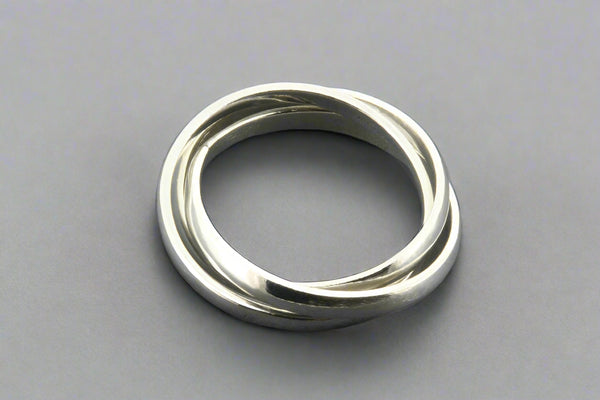 Silver ring with three interlocking bands on a gray background