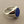 Load image into Gallery viewer, A silver signet ring with a round, polished blue lapis lazuli stone, displayed on a textured dark gray surface.
