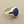 Load image into Gallery viewer, A silver signet ring with a round, deep blue lapis lazuli stone, photographed on a textured gray surface.
