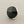 Load image into Gallery viewer, A silver-toned ring featuring a large, faceted black onyx cabochon, photographed on a dark gray textured surface.
