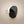Load image into Gallery viewer, A silver ring featuring a large, faceted black onyx stone, photographed on a dark gray textured surface.
