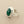 Load image into Gallery viewer, A silver ring featuring a large, oval-cut green faceted gemstone in a polished bezel setting, shown on a dark gray textured background.
