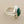 Load image into Gallery viewer, A silver ring featuring a large, faceted green gemstone in a polished bezel setting, displayed on a dark gray textured surface.
