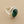 Load image into Gallery viewer, A silver ring featuring a large, oval-cut dark green faceted gemstone, photographed on a textured dark gray surface.
