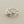 Load image into Gallery viewer, A silver ring with an organic, wavy band and textured, organic-shaped floral details on the front, displayed on a dark gray textured surface.
