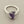 Load image into Gallery viewer, A silver-toned ring featuring a raw, irregular-cut purple amethyst gemstone in a prong setting, displayed on a dark gray textured surface.
