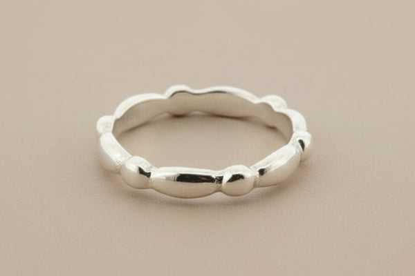 Silver ring with a textured edge on a gray background