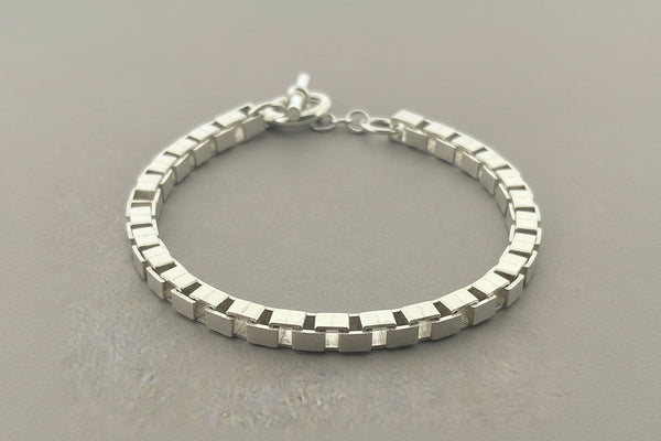 Silver bracelet on a gray background