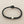Load image into Gallery viewer, Black braided bracelet with a silver clasp on a gray background
