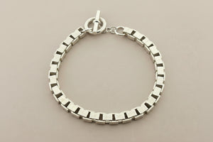 Silver bracelet on a dark gray background
