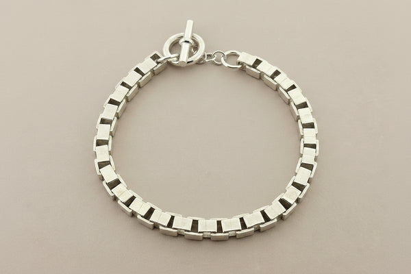 Silver bracelet on a dark gray background