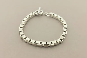 Silver bracelet on a gray background