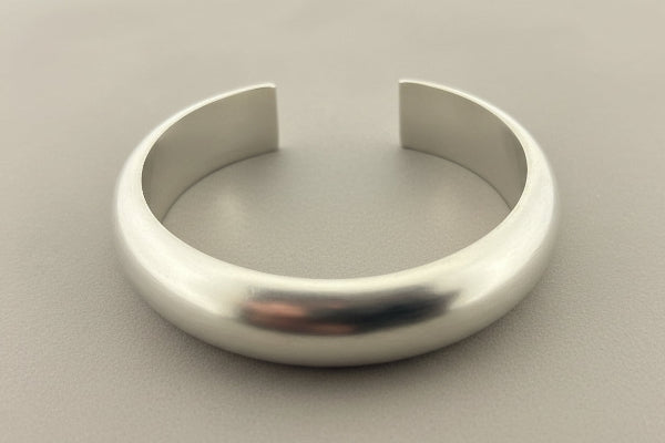 Silver bracelet on a gray background