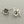 Load image into Gallery viewer, Pair of silver flower-shaped earrings on a gray background
