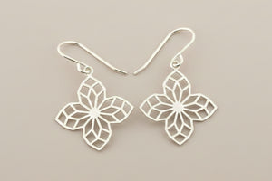 Silver floral earrings on a gray background