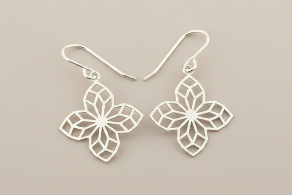 Silver floral earrings on a gray background
